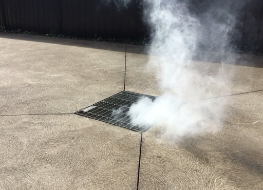 Image showing smoke coming from drain during smoke testing procedure