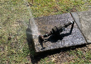 image of damaged water meter with water spraying out